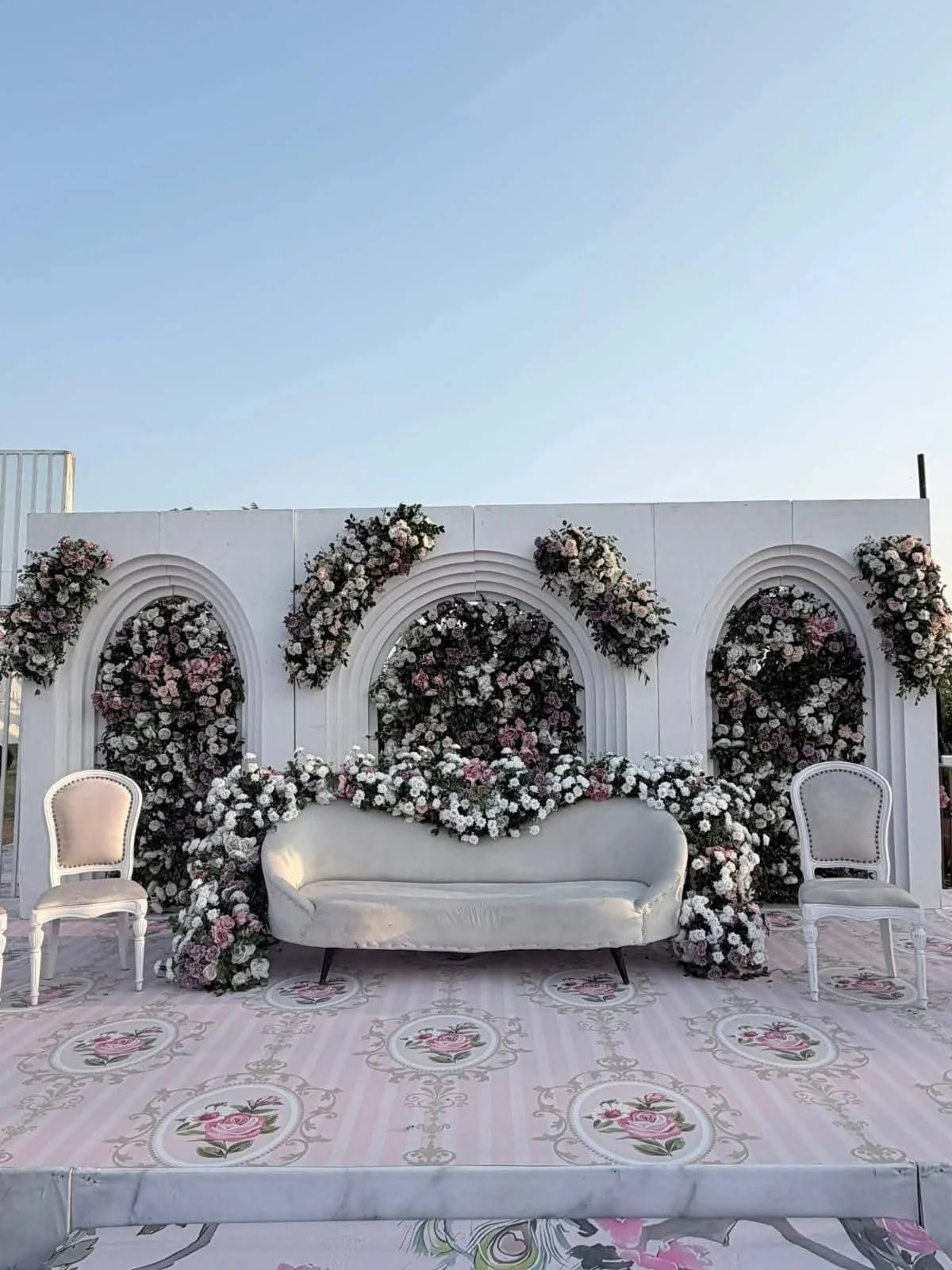 White floral wedding stage with arched panels and seating